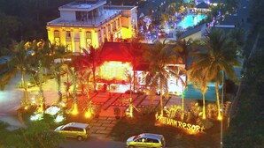 A resort with a pool, palm trees, and a sign reading "PHUAN RESORT".