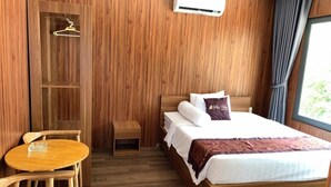 A wooden-paneled room with a bed, a small table, and chairs.