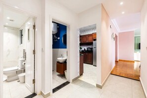 Un interior moderno con un baño, una cocina y un pasillo.