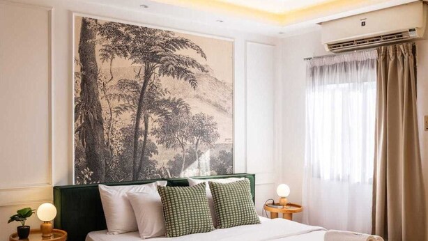 Un dormitorio moderno con una cama grande, un aire acondicionado de pared y un amplio ventanal con cortinas.