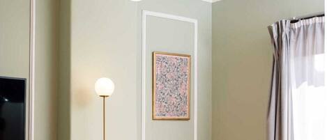 Una sala de estar con diseño moderno, que incluye un mueble de madera, un sillón tapizado en gris, una mesa de centro redonda de vidrio y una lámpara de pie.