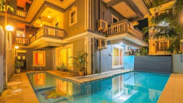 A multi-story building with a swimming pool, balconies, and outdoor lighting. - The Royal Mirage (Candolim)