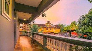 A corridor with a checkered floor leading to a balcony with a railing. - The Royal Mirage (Candolim)