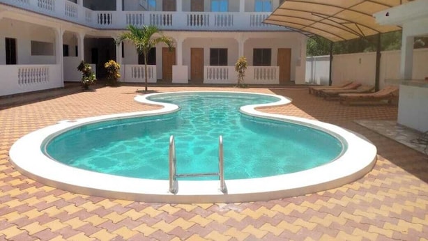 A swimming pool with a white border, surrounded by a tiled patio. - Diamond Luxury House Watamu (Watamu)