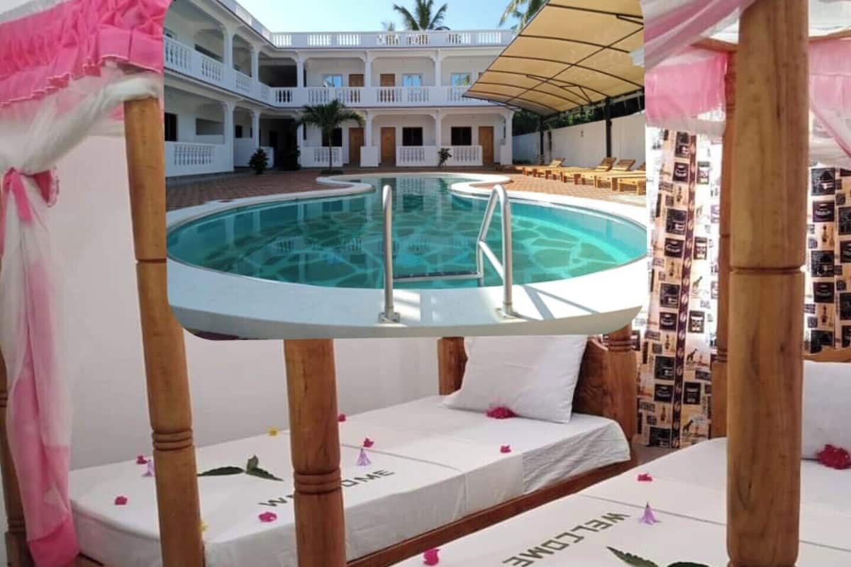 A hotel room with a pool, a balcony, and a view of the pool area.