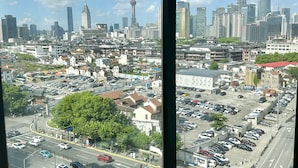 Un paysage urbain avec des gratte-ciel modernes, une tour imposante et un mélange de bâtiments traditionnels et contemporains.