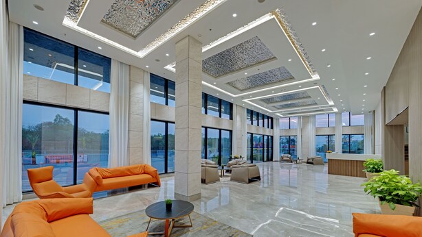 A spacious lobby with large windows, modern seating, and a polished floor.