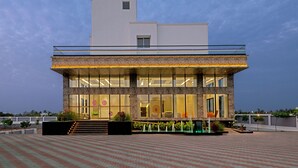 A modern building with a glass facade, a flat roof, and a landscaped courtyard.