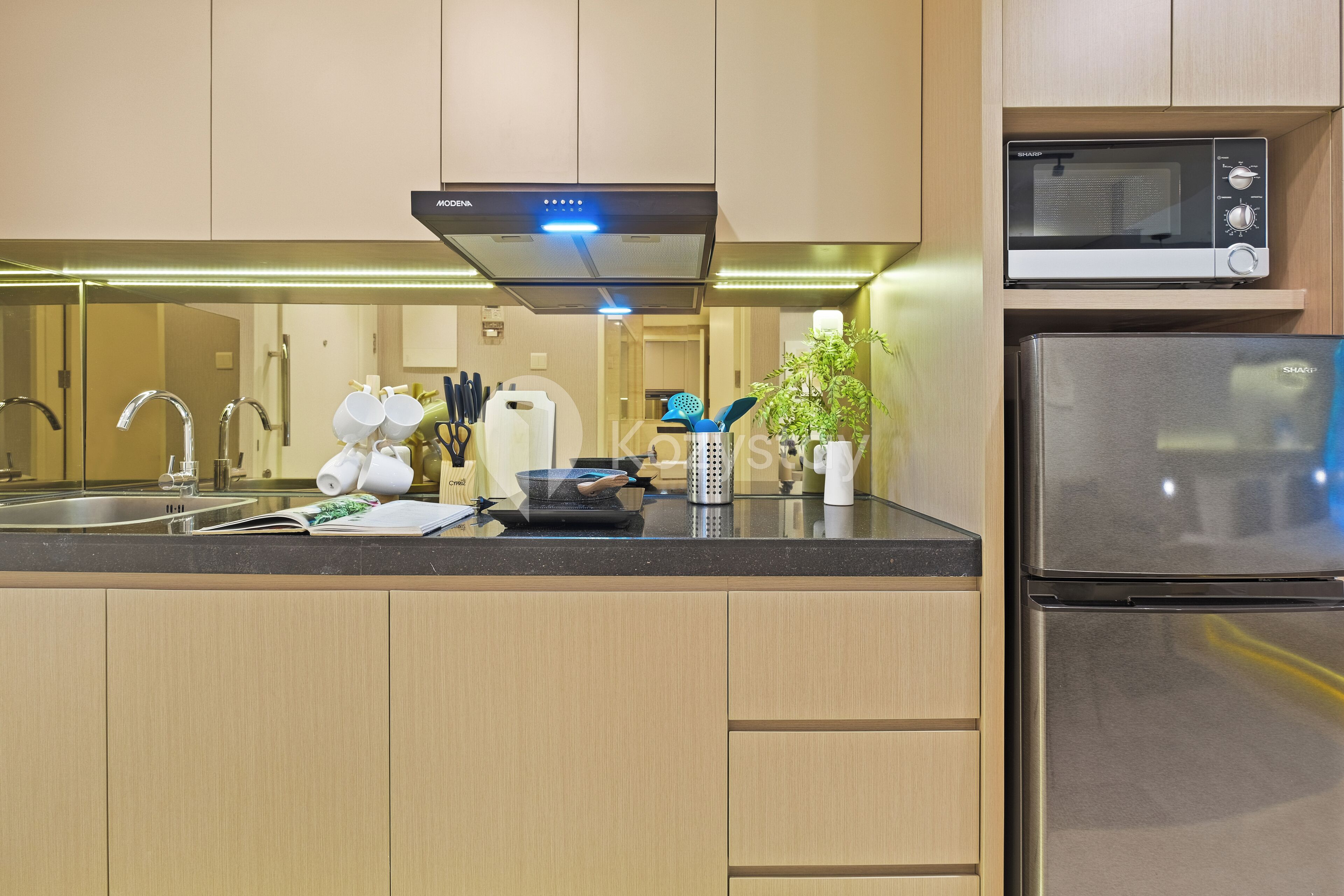 A modern kitchen with a stainless steel refrigerator, a microwave, and a built-in oven.