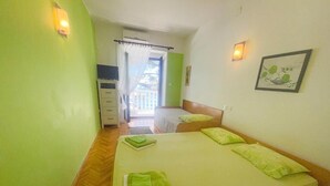A room with a bed, a desk, and a view of the outside. - Apartment Dea 1 (Jadranovo)