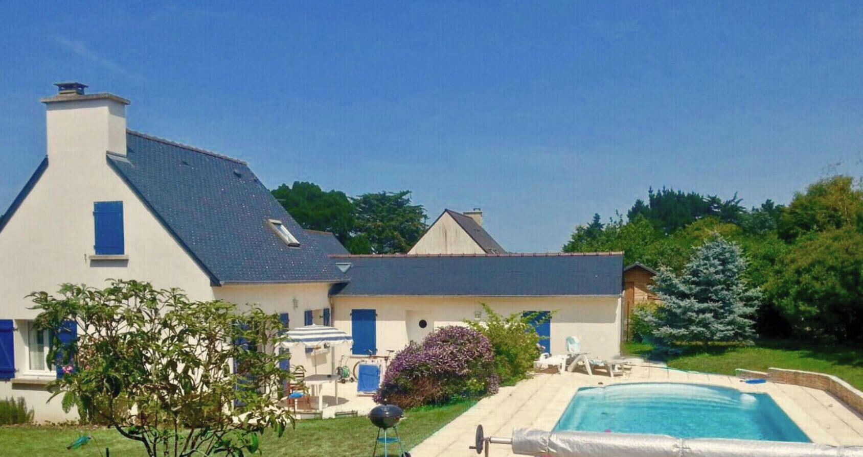Une maison à deux étages avec une piscine, un barbecue et un jardin où poussent différentes espèces de plantes.