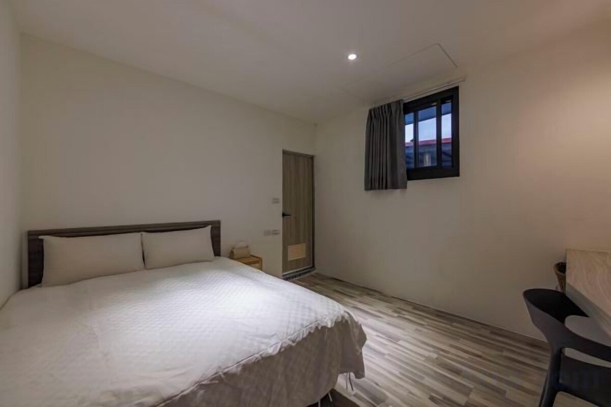 Ein Schlafzimmer mit einem Bett, einem Schreibtisch und einem Fenster.