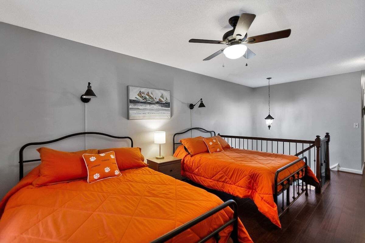 Ein Schlafzimmer mit zwei Betten, einem Deckenventilator und einem Nachttisch mit Lampe.