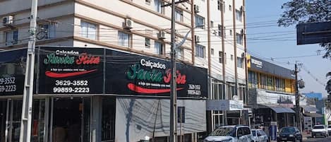 A multi-story hotel named HOTEL GLOBO with a modern facade, multiple air conditioning units, and a visible storefront with signage for 'Calgados Santa Joana'.