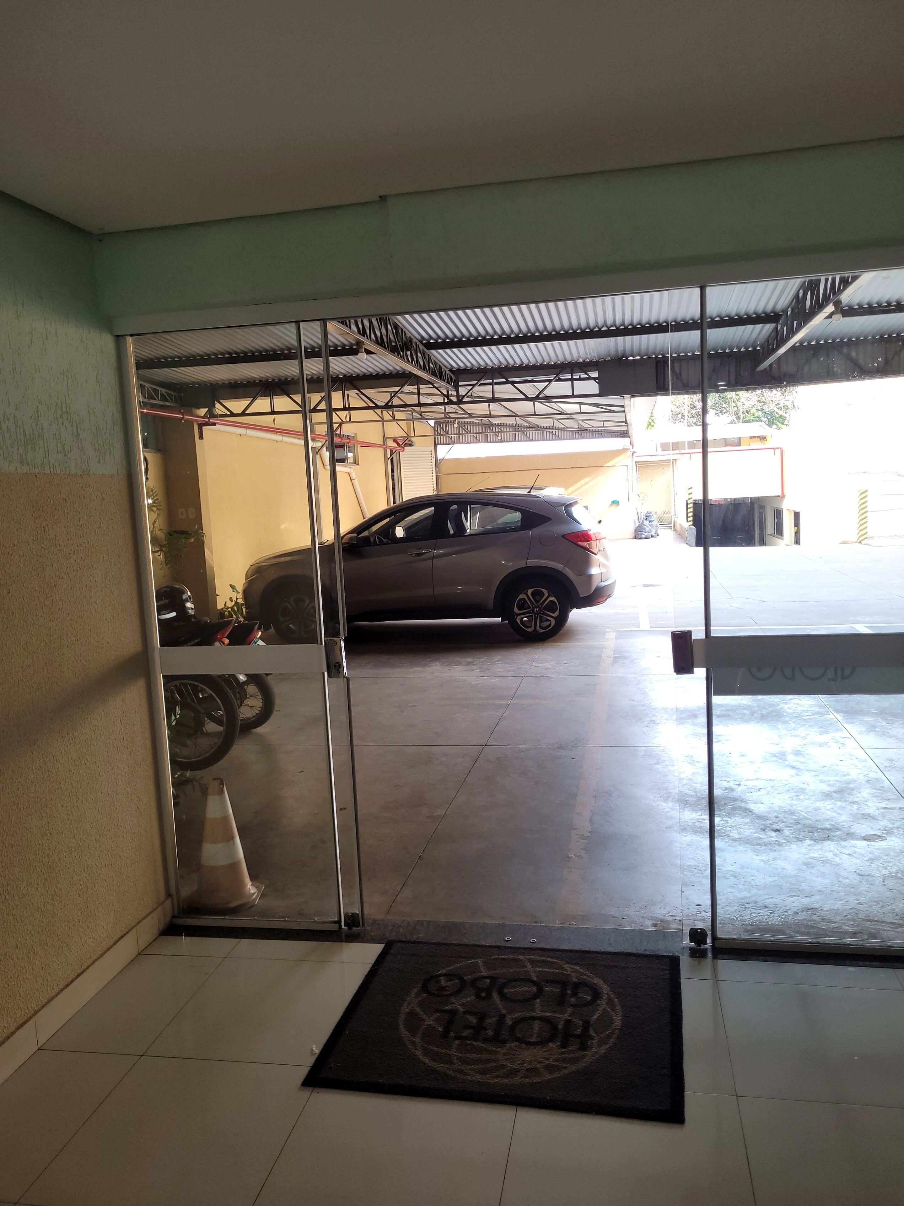 Un coche estacionado en un garaje con puerta de vidrio.