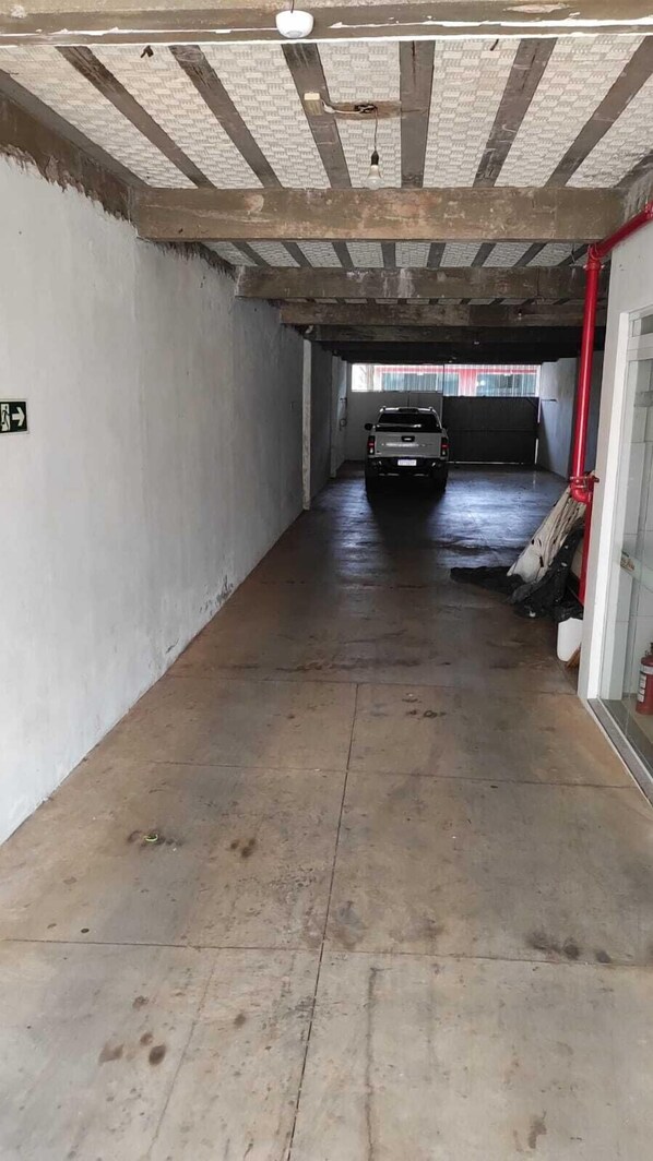 A parking garage with a white car parked in the distance.