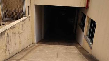 A concrete floor with visible cracks and a metal fence on the left.
