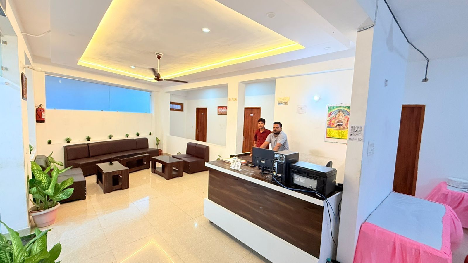 A reception area with a reception desk, seating area, and a ceiling fan.