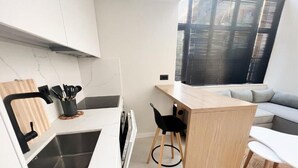 Une cuisine moderne dotée d’un évier encastré, d’un plan de travail en bois et de chaises noires.