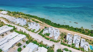 A coastal resort with white buildings, a beach, and boats in the water. - Fumba Town Private Residences (Kombeni)