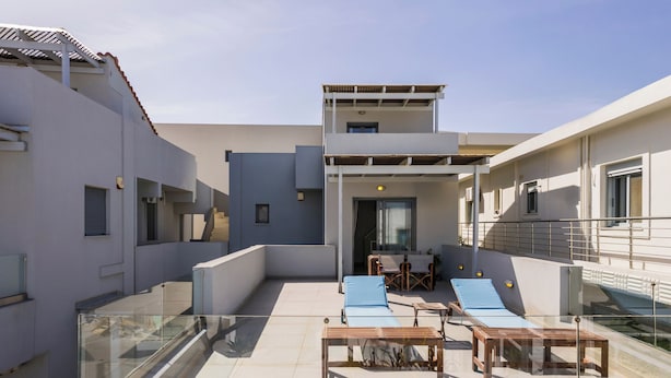 A rooftop terrace with sun loungers, a table, and a glass balustrade. - Alisahni Villa (Daratsos)