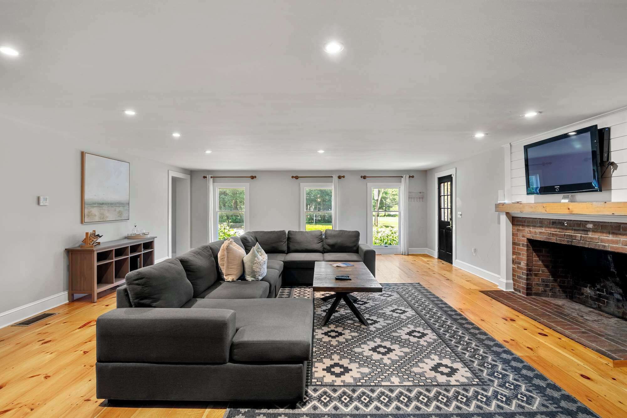 Un salon moderne avec un canapé d’angle, une table basse et une cheminée.