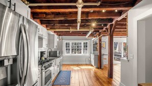 A kitchen with stainless steel appliances, wooden beams, and a view to the outside. - Steps to Dining, Less than 1 mile to Bayside Beaches! (Dennis)