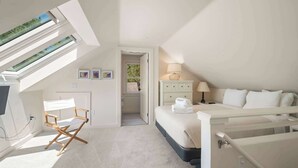 Een slaapkamer met dakraam, een bed, een bureau en een stoel.