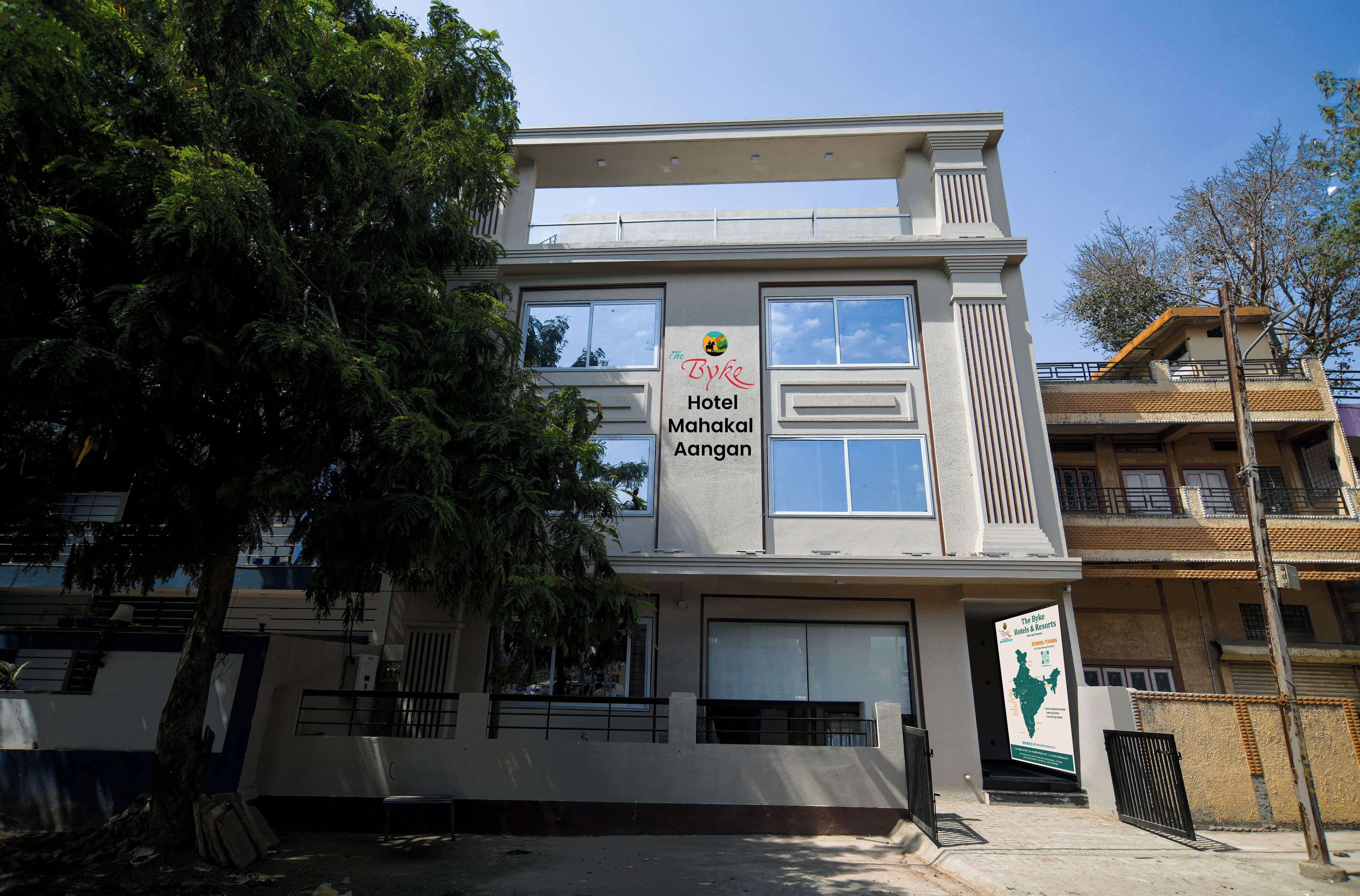 A modern hotel building with a sign for "The Byke Hotel Mahakal Aangaan".