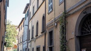 Un carrer estret amb edificis que tenen finestres d'arc i persianes.