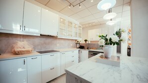 A modern kitchen with white cabinetry, a marble countertop, and pendant lighting. - Villa Dahi Almerimar with Private Pool, Bar, Barbeque and Panoramic Sea Views (El Ejido)