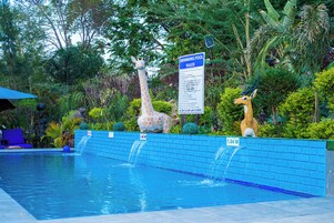Una piscina al aire libre, sombrillas, sillones reclinables de piscina