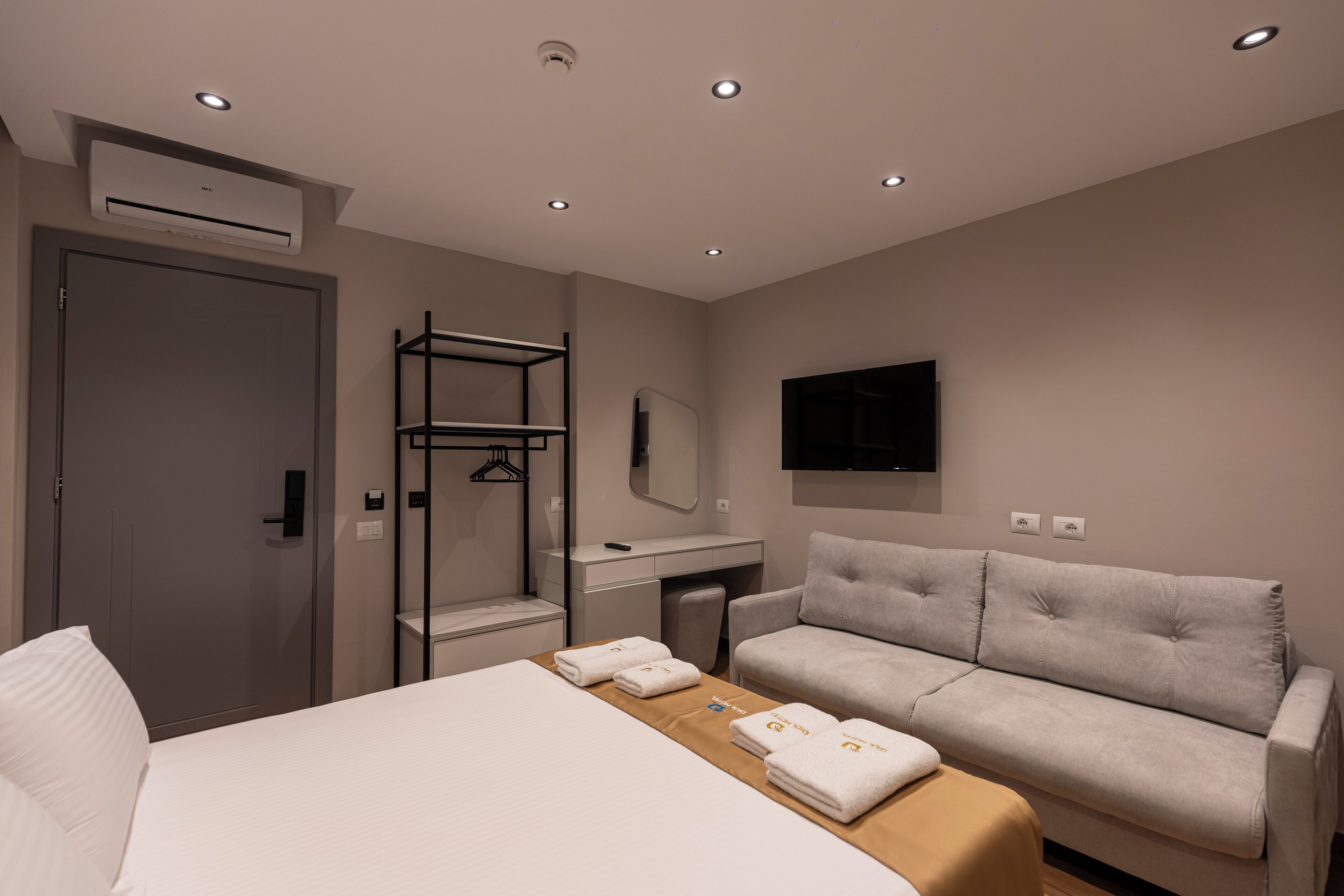 Une chambre d’hôtel moderne équipée d’un lit, d’un canapé, d’un bureau et d’une télévision.