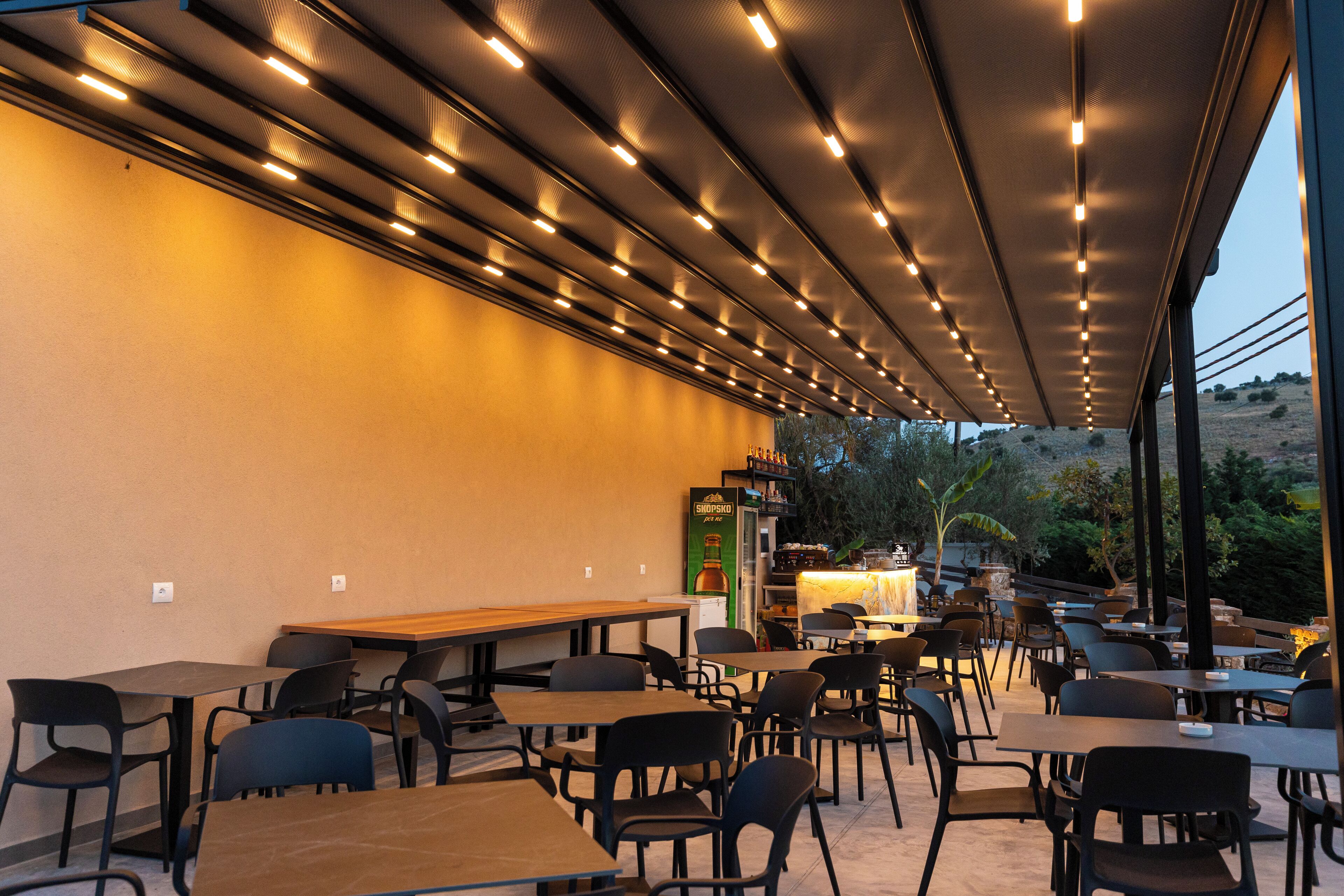 An indoor dining area with tables and chairs, a counter with a menu, and a view of the outdoors.