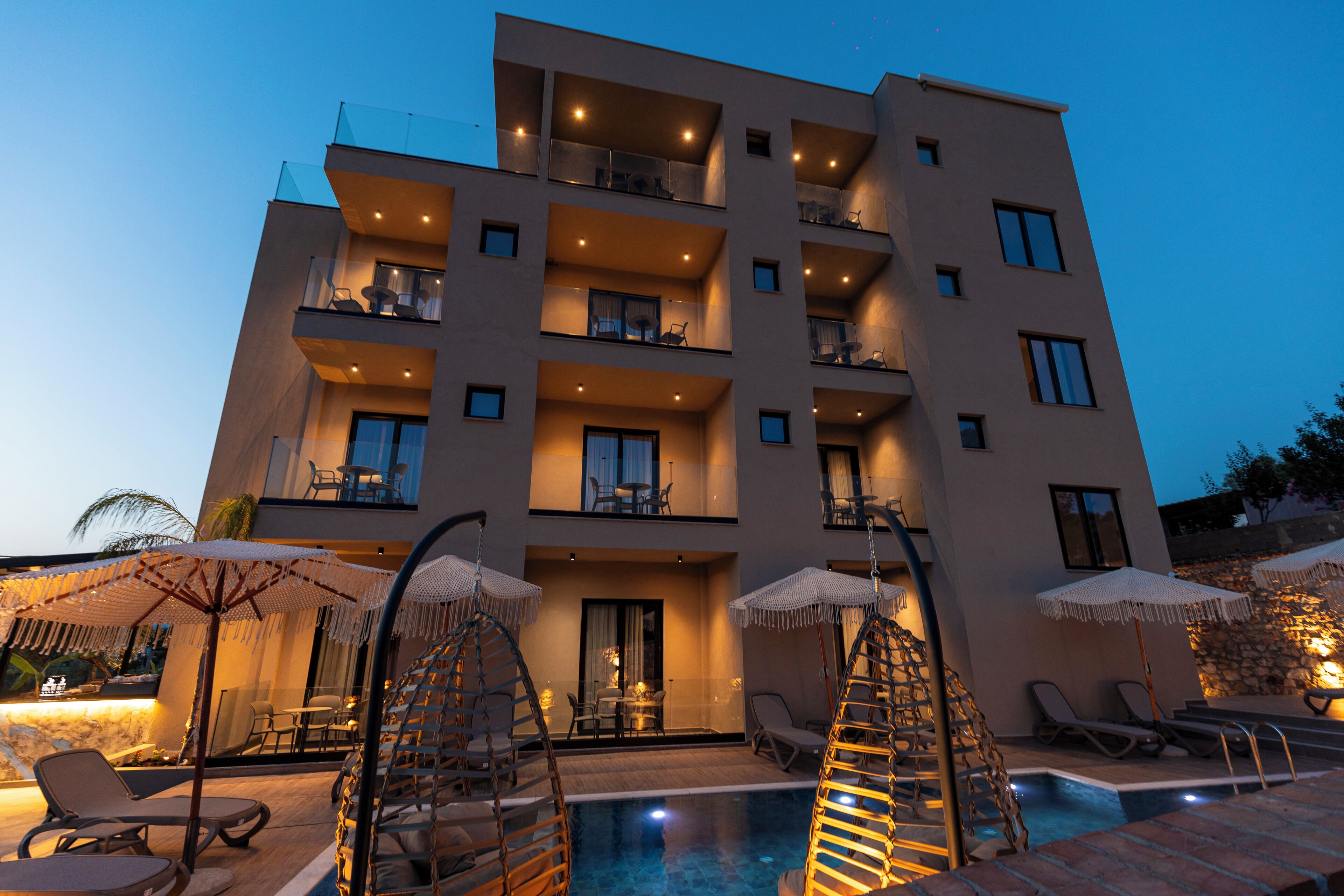 A multi-story hotel with balconies, a swimming pool, and outdoor seating areas.