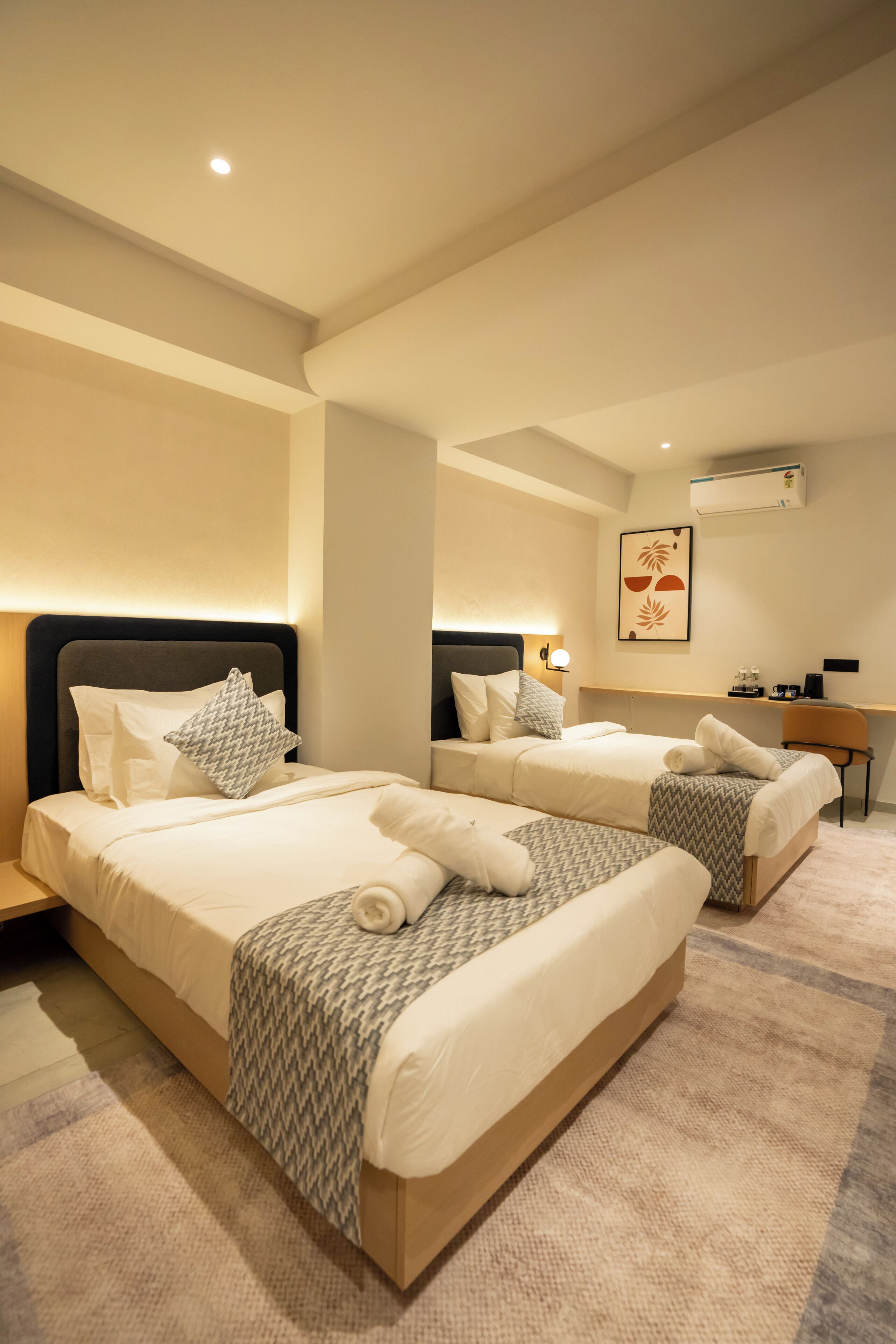 Una habitación de hotel moderna con dos camas, un escritorio y una silla.