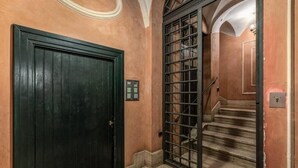 A staircase with a metal gate and a dark wooden door. - Domus Mondrian - Apartment in Central Roma (Roma)