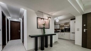 Eine moderne Küche mit weißen Schränken, einem eingebauten Backofen und einem Edelstahlkühlschrank.