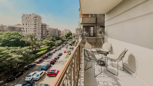 Ein Balkon mit Blick auf eine belebte Straße und hohe Gebäude.