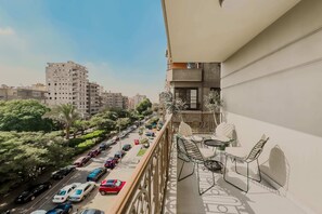 A balcony with a view of a busy street and tall buildings.