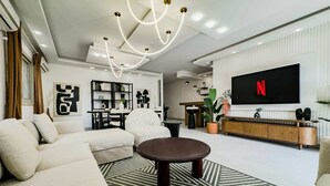 Ein modernes Wohnzimmer mit einem Ecksofa, einem runden Couchtisch und einem flachbildfernseher an der Wand.