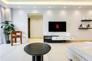 Basic Apartment (Ample & Artistic) | Living area | 55-inch Smart TV with satellite channels - Xuru Stays I Valory - 5 Min to Airport (Cairo)