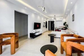 Basic Apartment (Ample & Artistic) | Living area | 55-inch Smart TV with satellite channels - Xuru Stays I Valory - 5 Min to Airport (Cairo)