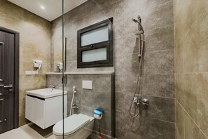 A modern bathroom with a toilet, sink, and shower.