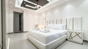 A modern bedroom with a large bed, a bedside table, a mirror, and a ceiling light fixture. - Xuru Stays I The Bold & Bright 3bdr Apt. 15 Min To Airport (Cairo)
