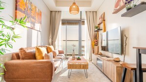 A modern living room with a sofa, coffee table, TV, and decorative items.