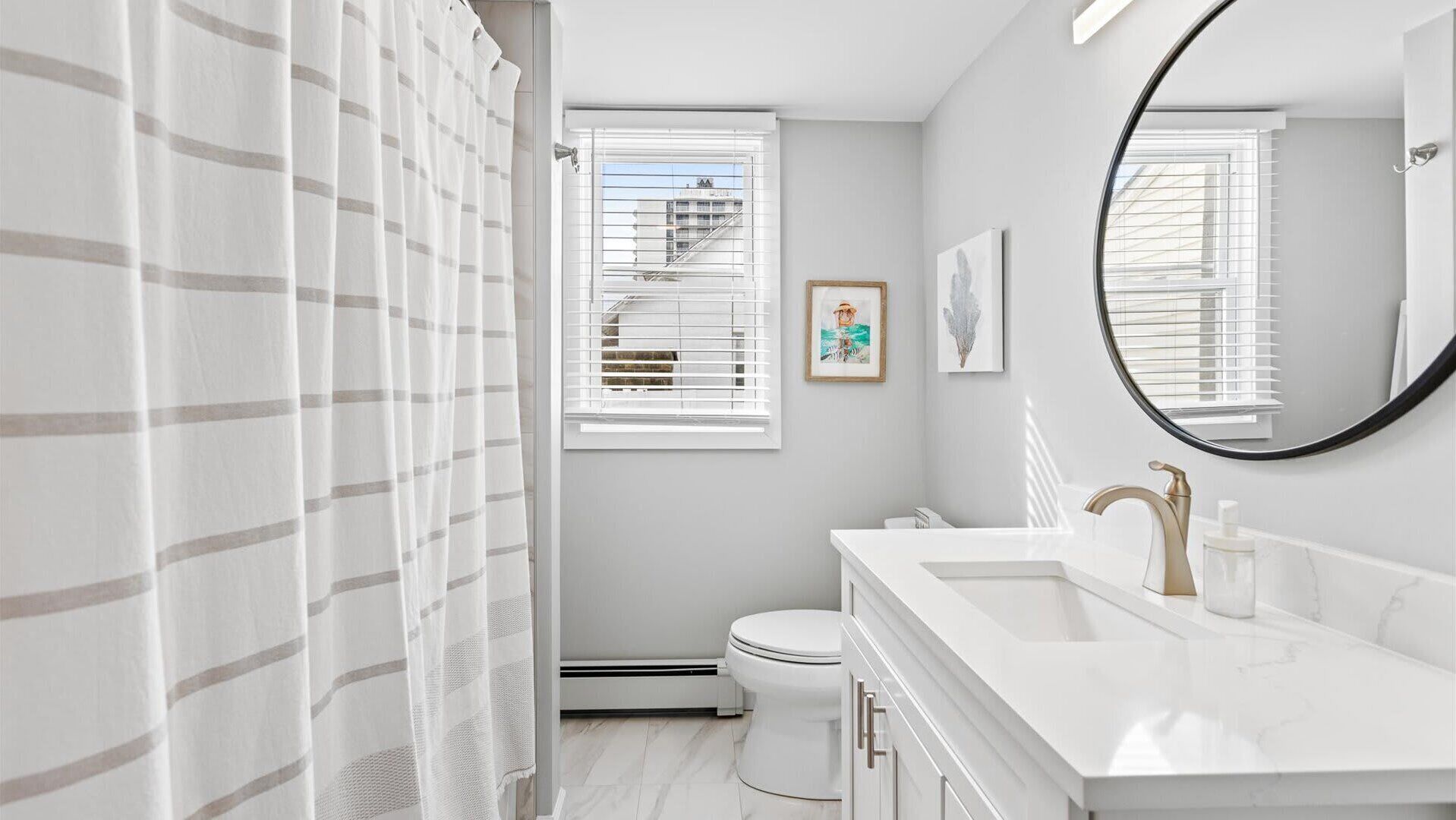 A modern bathroom with a shower, toilet, and vanity.