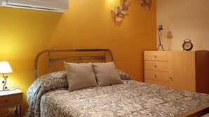 Ein Schlafzimmer mit Bett, Nachttisch, Lampe, Kommode und Wanddekorationen.
