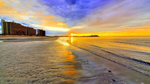 A beach with a hotel in the background. - BeachBumCondos (Puerto Peñasco)