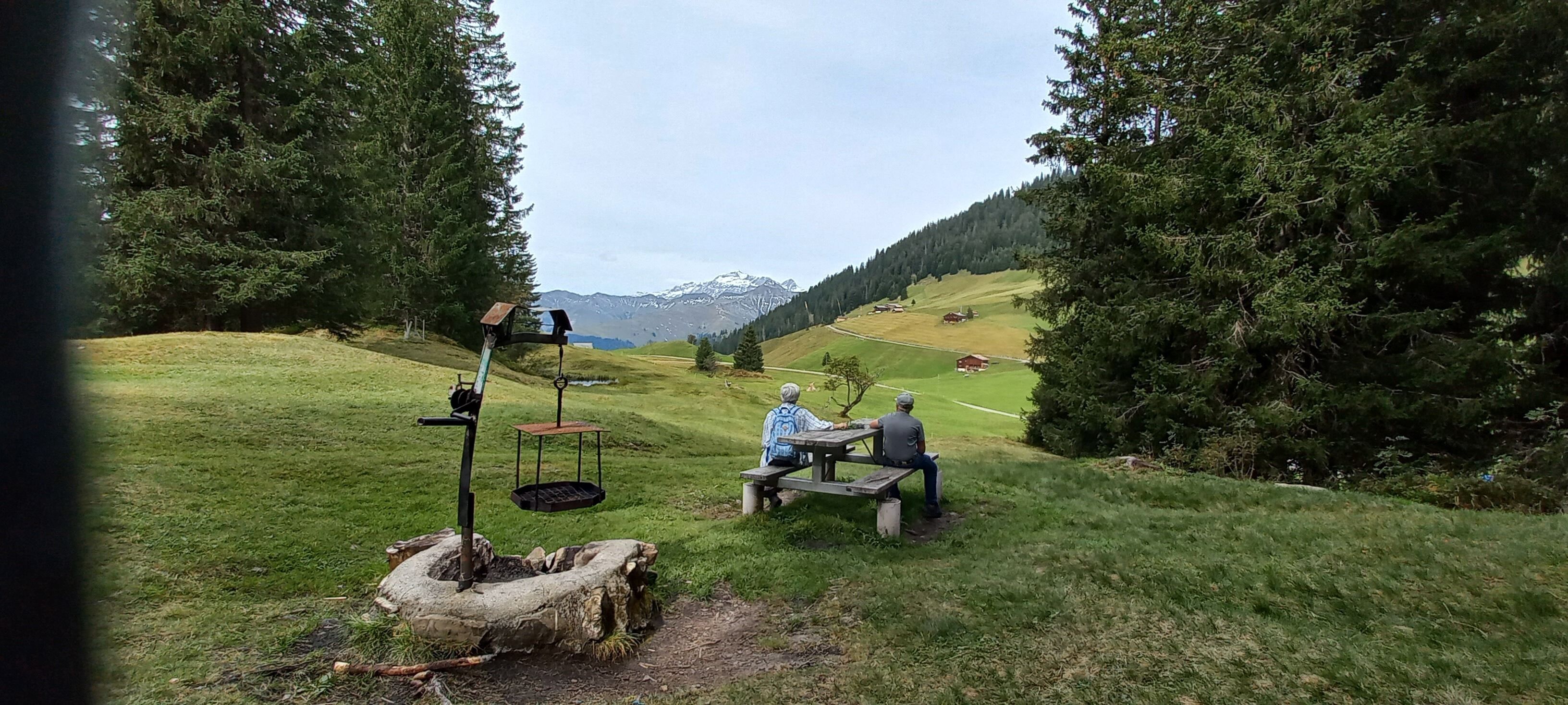 Un cadre extérieur rustique avec un banc en bois et une pompe à eau ancienne.